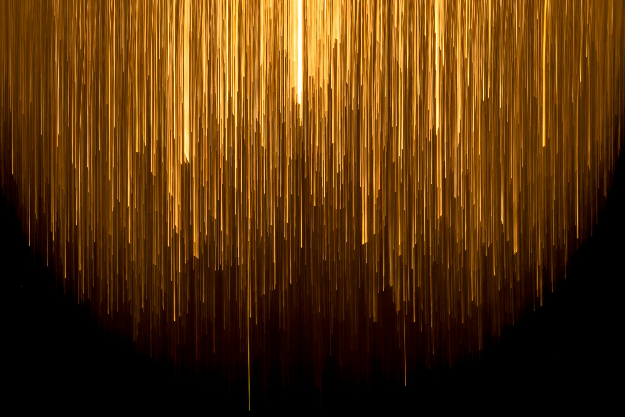 Descending gold bars of light on a dark background