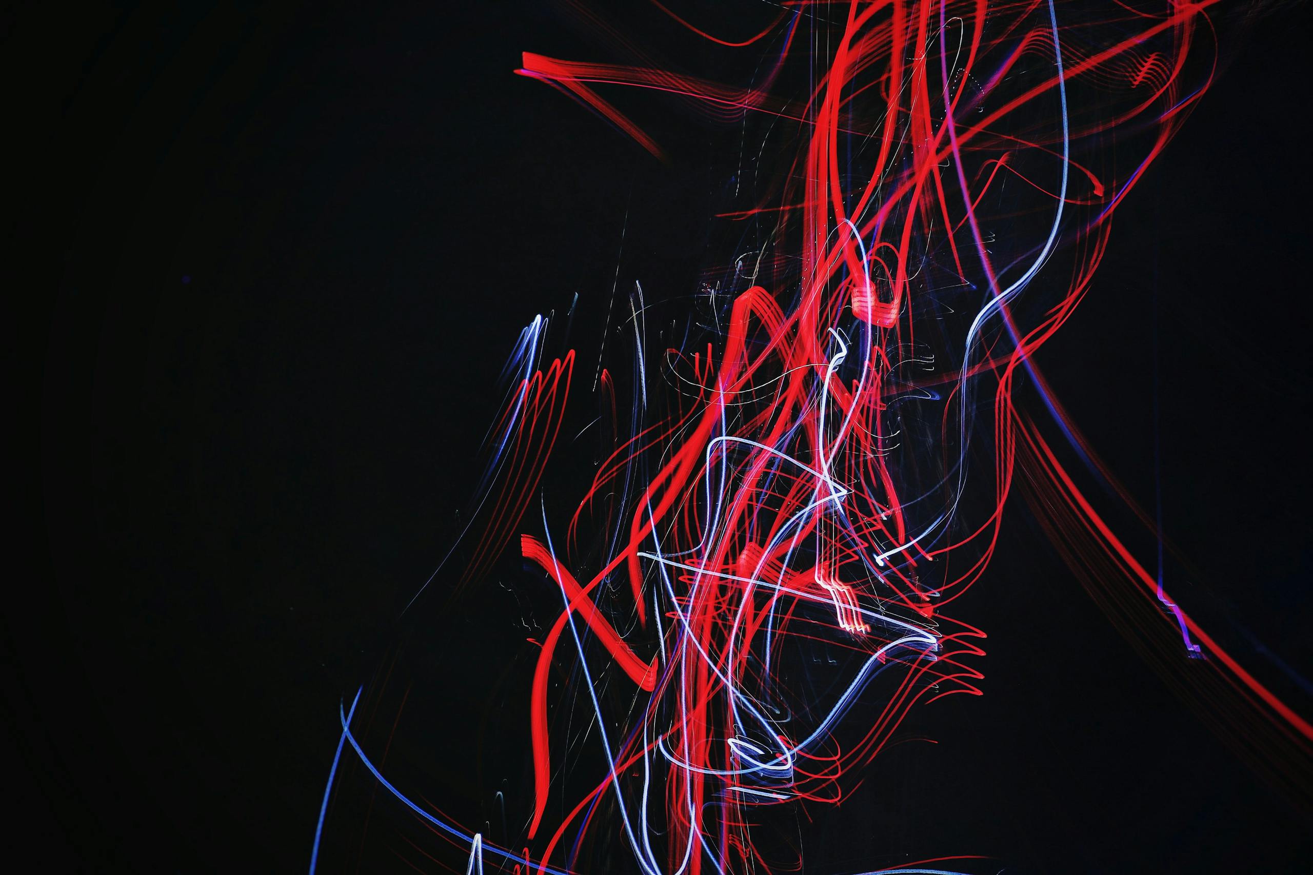 Squiggly lines of blue and red light on a dark background