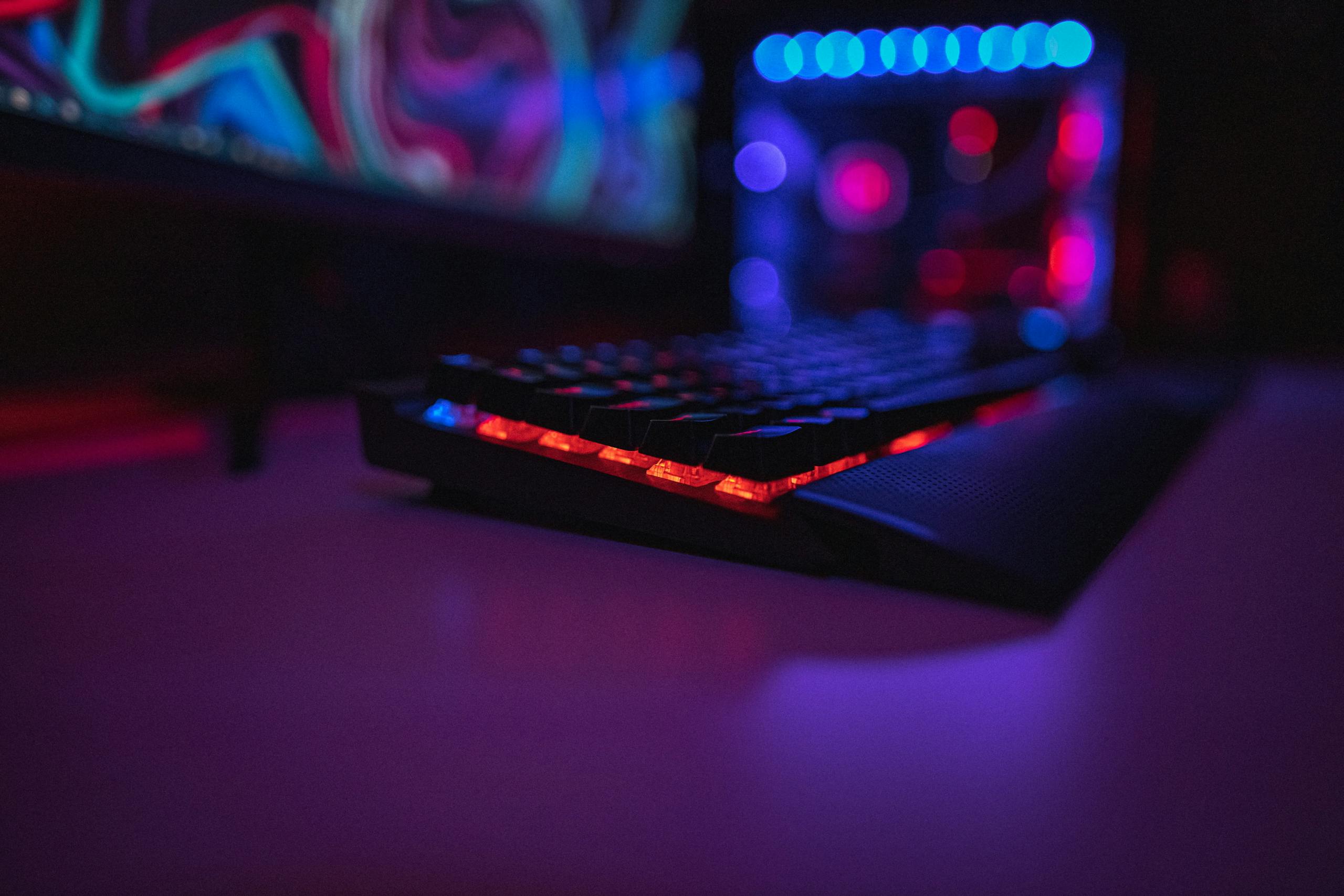 Keyboard on desk lit in blue and purple light