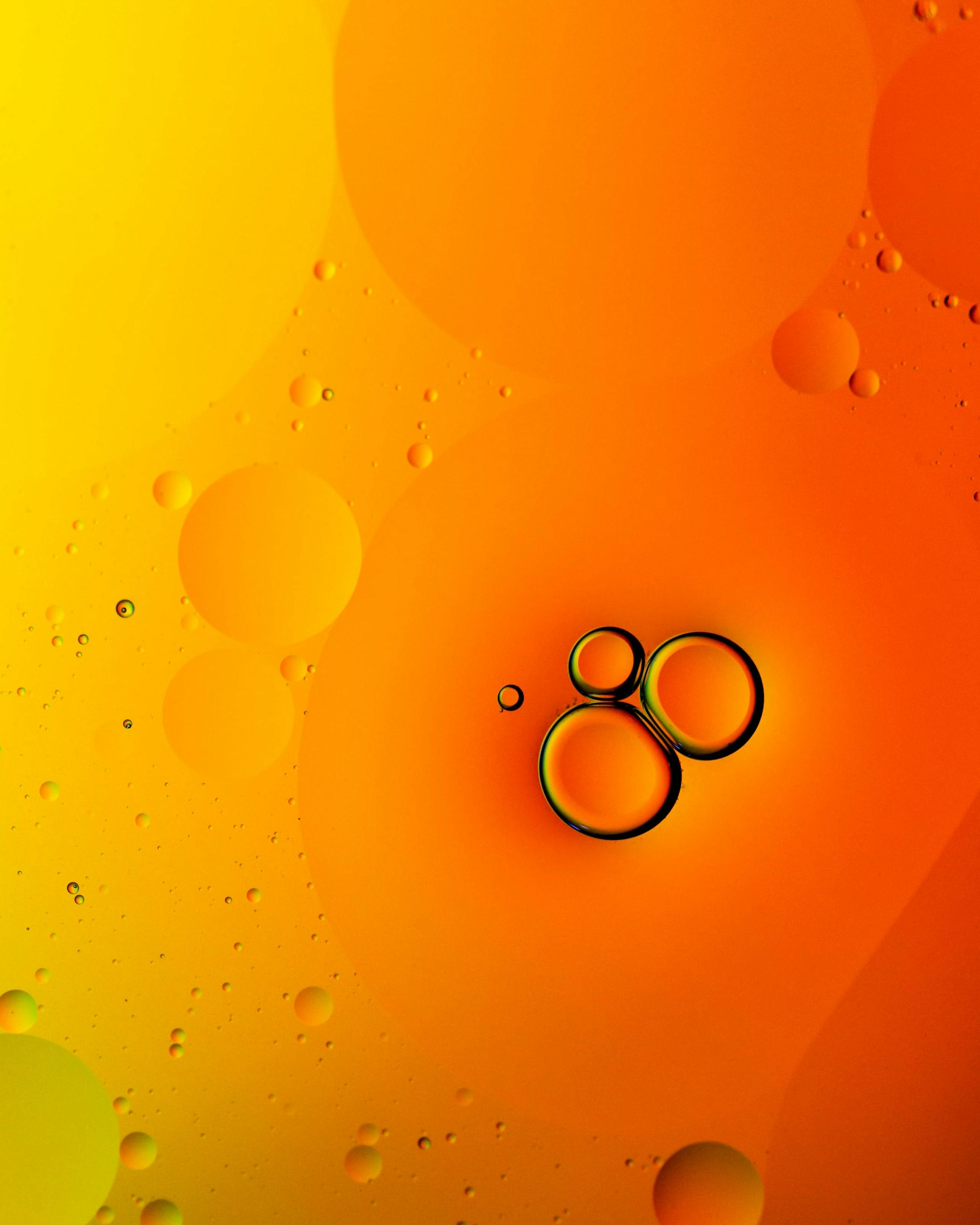 Oil droplets in water on and orange and yellow background